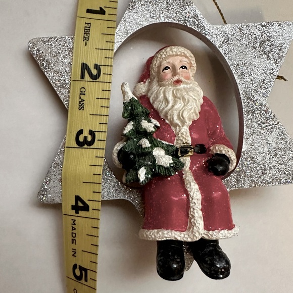 A Glittering Silver Star Christmas Ornament with a jolly Santa holding a Tree - Picture 5 of 6